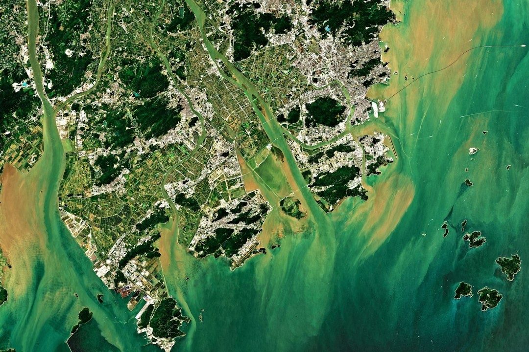 Satellite view of coastal cities, waterways, islands, and surrounding sea