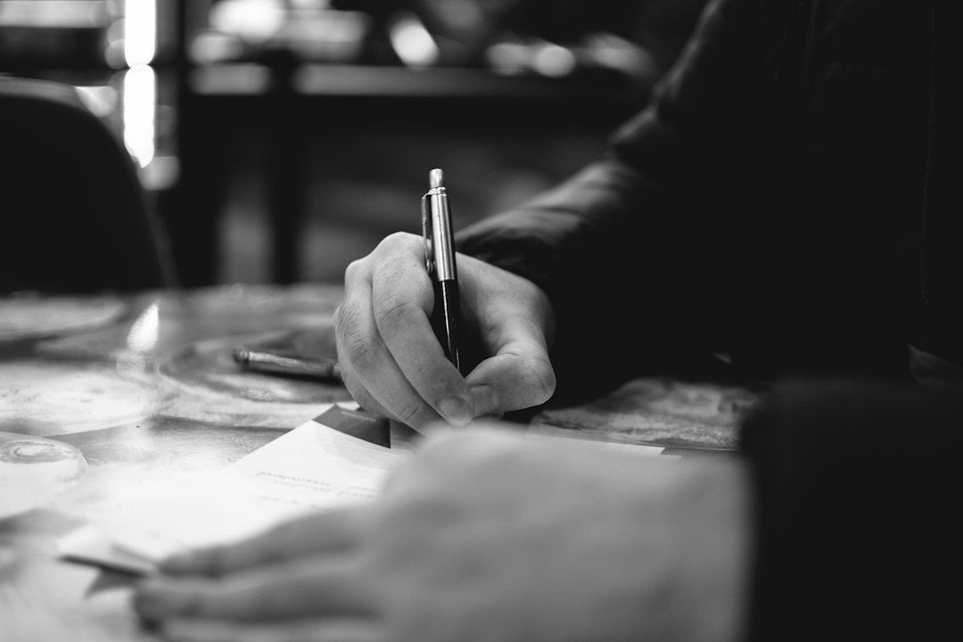 Person writing notes by hand on papers at a desk